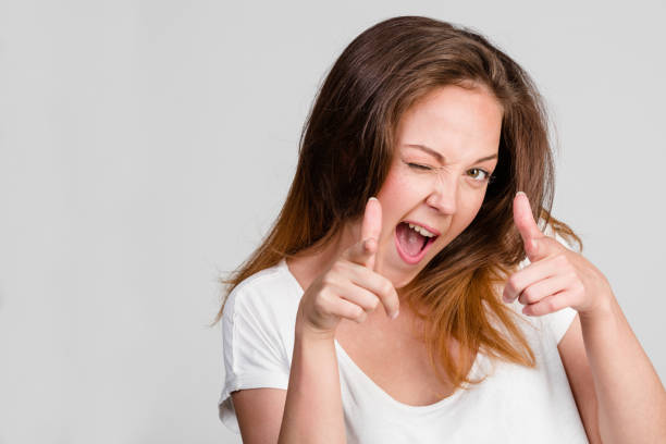 istock brunette with emotion finger up and winking eye 908340836