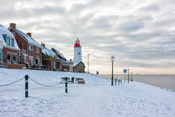 istock Dutch winter with snow and view at lighthouse village Urk 908344676