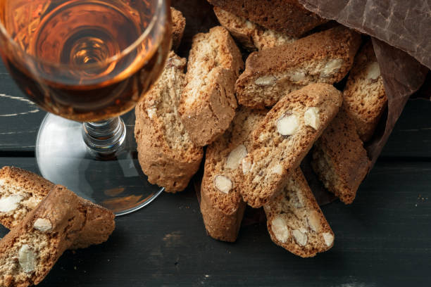 итальянское печенье cantuccini и бокал вина - бискотти стоковые фото и изображения