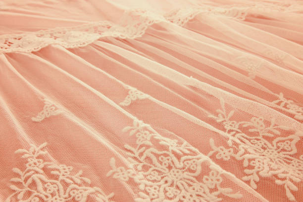istock Background of white delicate lace fabric over pink background. 908347678