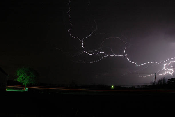 Lightning over lone tree stock photo