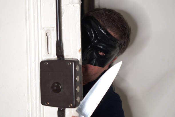 домохохо грабитель в маске, вооруженный кинжалом, открывает дверь - housebreaker стоковые фото и изображения