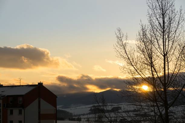 istock Sunset in the town during winter with snow on the roofs. 908359520