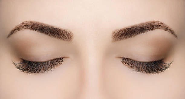 Beautiful Woman with long lashes in a beauty salon. Beautiful Woman with long lashes in a beauty salon. Eyelash extension procedure. false lashes stock pictures, royalty-free photos & images