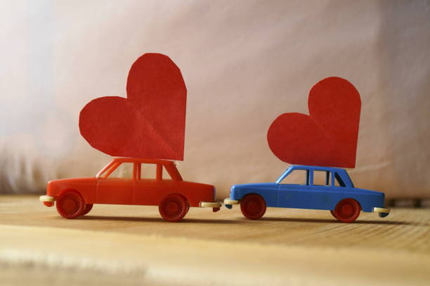 istock Miniature plastic cars carrying a red heart 908379656