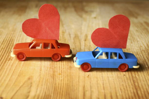 istock Miniature plastic cars carrying a red heart 908379660