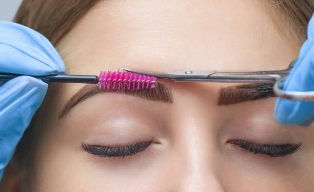 istock The make-up artist cuts her eyebrows with scissors. 908379692