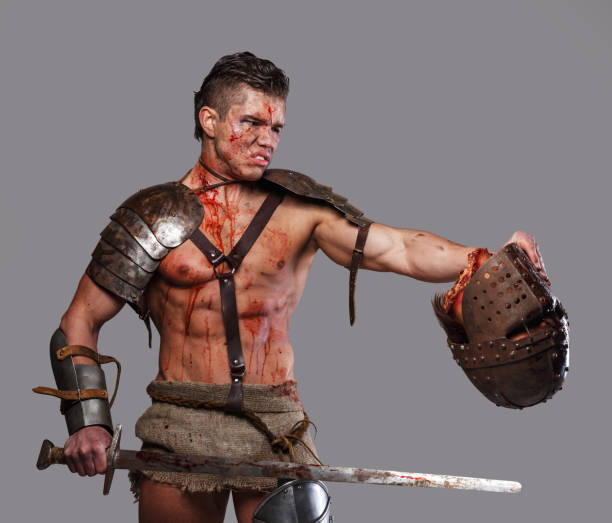 istock Wounded gladiator with muscular body in armour 908382306