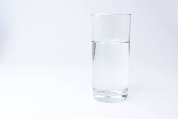 istock Clean drinking water poured into a glass on a light background 908382924