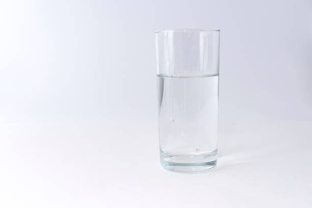 istock Clean drinking water poured into a glass on a light background 908382934