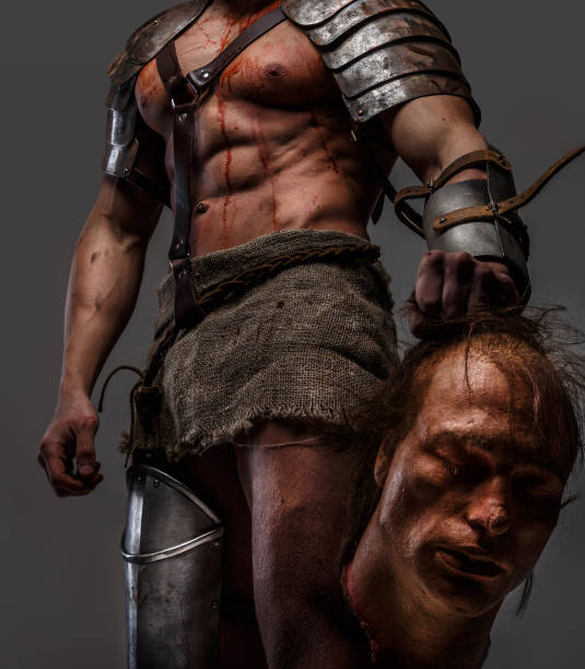 istock Wounded gladiator with muscular body in armour 908385294