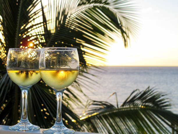 istock Two glasses of sparkling white wine on a balcony overlooking the ocean 908389380