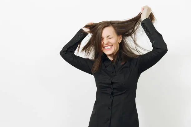 Beautiful fun caucasian young smiling brown-hair business woman in black classic shirt and skirt holding hair with hands isolated on white background. Manager or worker. Copy space for advertisement
