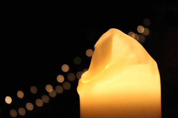 istock candle in dark room with lights in background 908391964