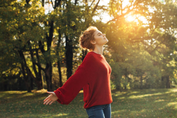 istock Beautiful young woman standing in the park 908401130