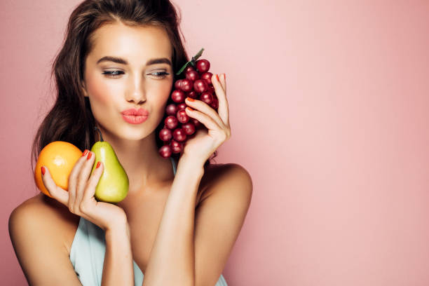 женщина, держащая фрукты - eating female healthcare and medicine healthy lifestyle стоковые фото и изображения