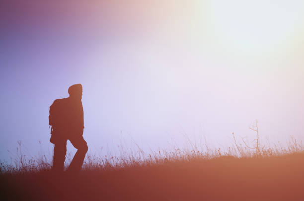 istock Climber silhouette on the grassland, concept image 908403934