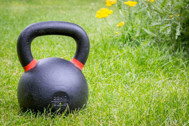 istock kettlebell on grass - backyard fitness 908409838