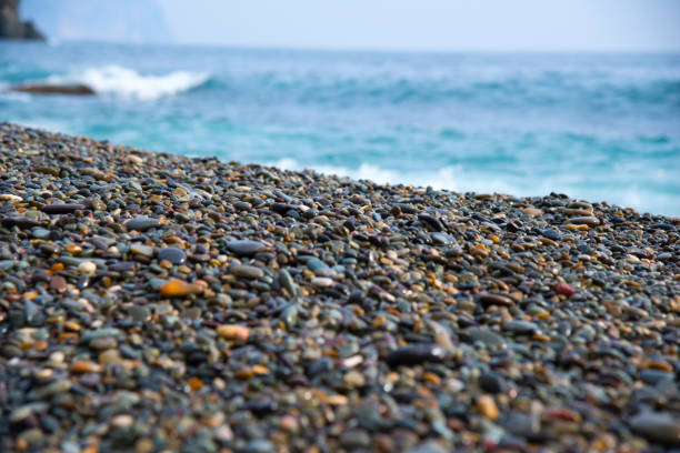 pietre di ciottoli in fondo al mare. onde setosi di mare blu - pebble beach california foto e immagini stock