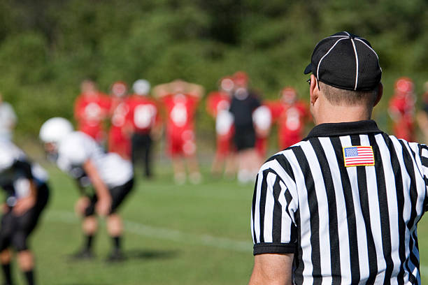 American football referee viewed from the rear at the game Referee on sideline of American football game. sports official stock pictures, royalty-free photos & images