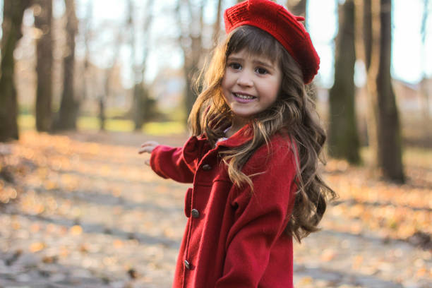 istock Beutiful girl in red coat in park 908443970