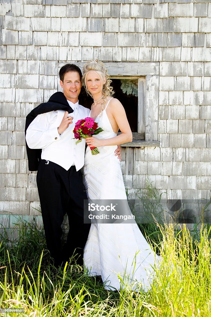 Wedding Couple Portrait of a bride and groom leaning up against an old building. Adult Stock Photo