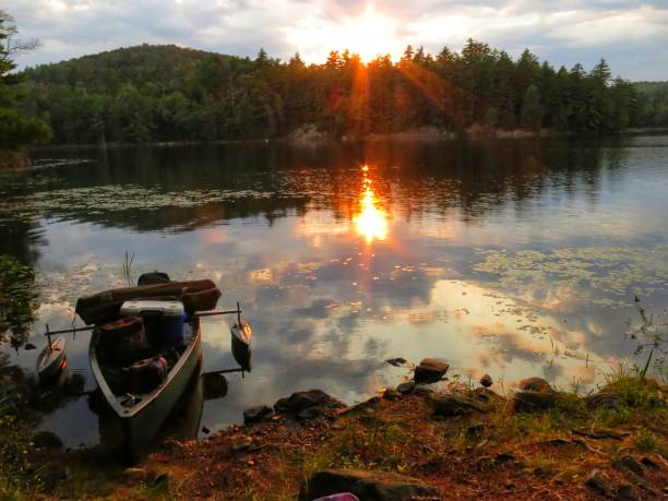 istock Camping Canoe, Outriggers, Treelined Adirondack Crane Pond Sunset Reflection 908450384