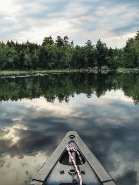 istock Canoe, Treelined Adirondack Crane Pond Sunset Reflection on Water. Lilypads 908450460