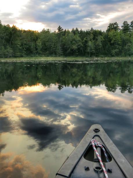 istock Canoe, Treelined Adirondack Crane Pond Sunset Reflection on Water. Lilypads 908450494