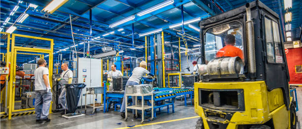 istock Forklift and manual workers in a factory 908451068
