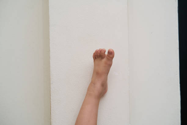 Children's foot on the white wall