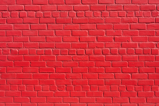 Close-up texture background image of a red painted brick wall.