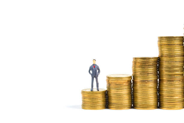 istock Figure miniature businessman or small people standing on first step of coin stack, isolated on white background for money and financial business concept. 908483808