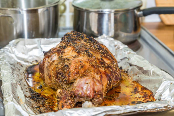 istock Closeup cooked lamb leg joint on roasting tin foil ready for serving 908505846