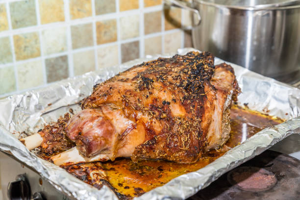 istock Closeup cooked lamb leg joint on roasting tin foil ready for serving 908505882