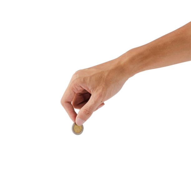 istock Female hand holding coin isolated on white background with clipping path. 908515416