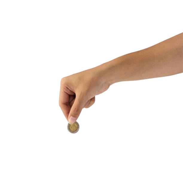 istock Man hand holding coin isolated on white background with clipping path. 908515418