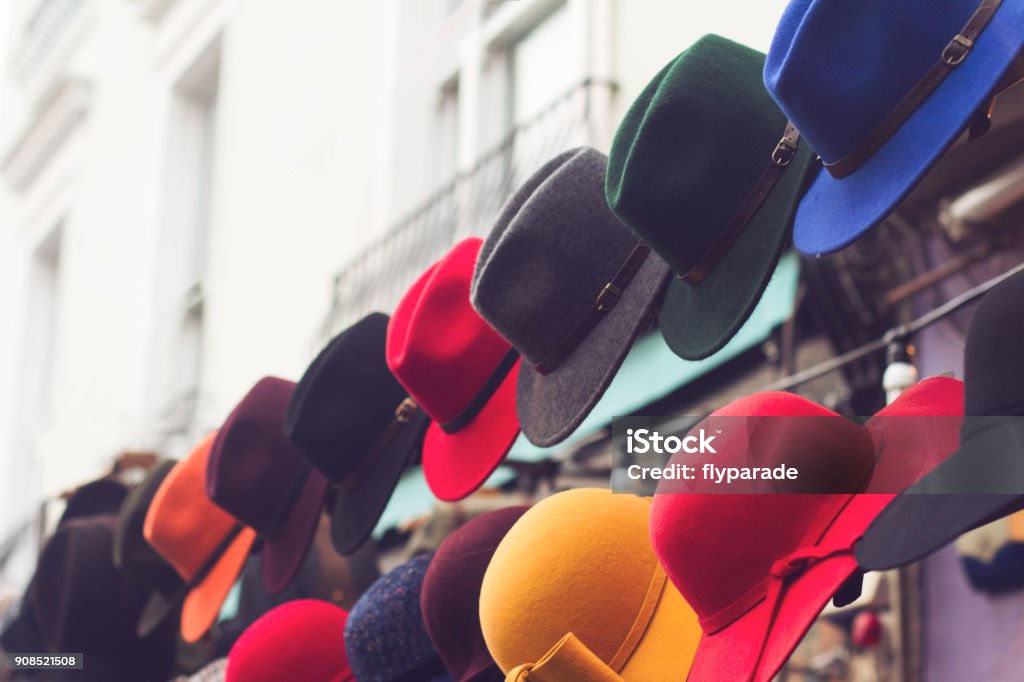 stand with colorful hats on store entrance sideview of store entrance stand with row of hats in different colors and designs Hat Stock Photo