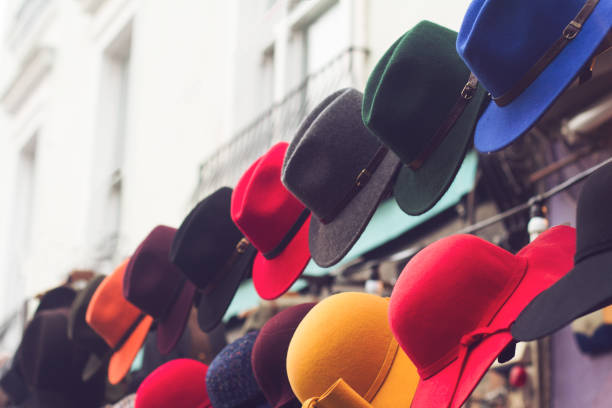 stand with colorful hats on store entrance sideview of store entrance stand with row of hats in different colors and designs london memorabilia stock pictures, royalty-free photos & images