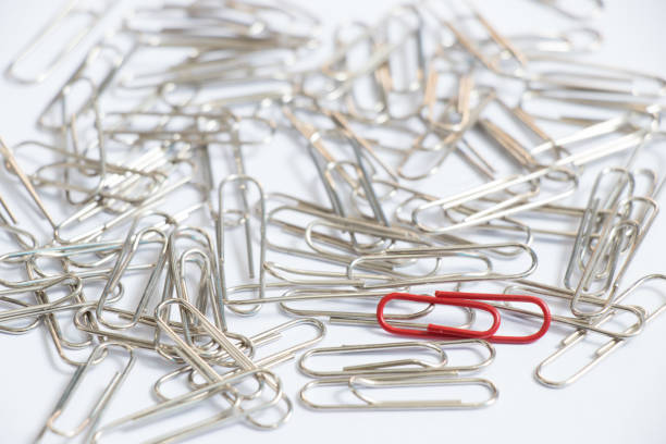 Red color paper clip with another silver item on white background (Concept differentiation, unique, limited or special one)