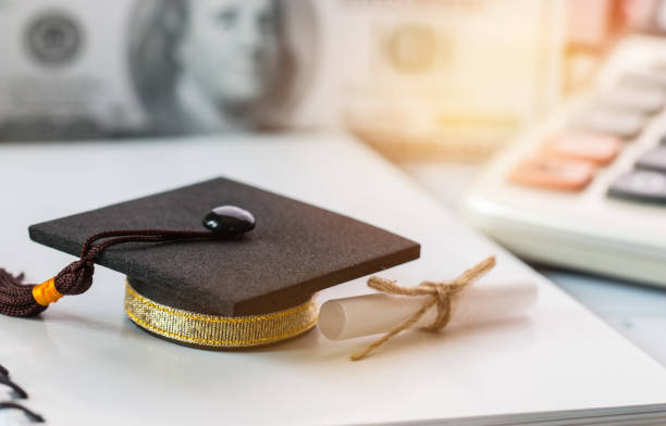 istock Graduate study international abroad concept, Graduation cap scroll certificate near documents report chart,blur US Dollar. Graduate study abroad program for students foreign, Finance Education Concept 908524790