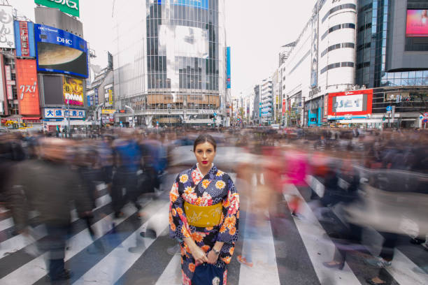 British woman in kimono standing in busy Shibuya crossing British woman in kimono standing in busy Shibuya crossing Long Time Exposure stock pictures, royalty-free photos & images