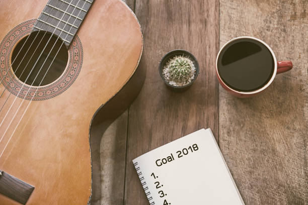 istock List go goal 2018 on paper note with coffee cup and guitar on wooden table. 908534636