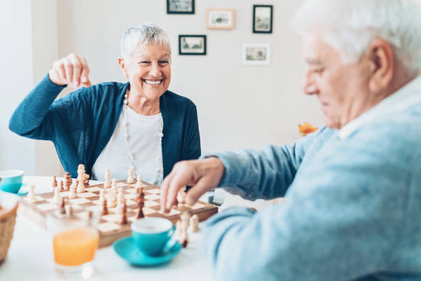 Always having fun together Happy senior couple playing chess at home senior chess stock pictures, royalty-free photos & images