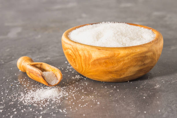 istock White sugar sugar in a wooden plate with a dustpan on a dark background. 908538468