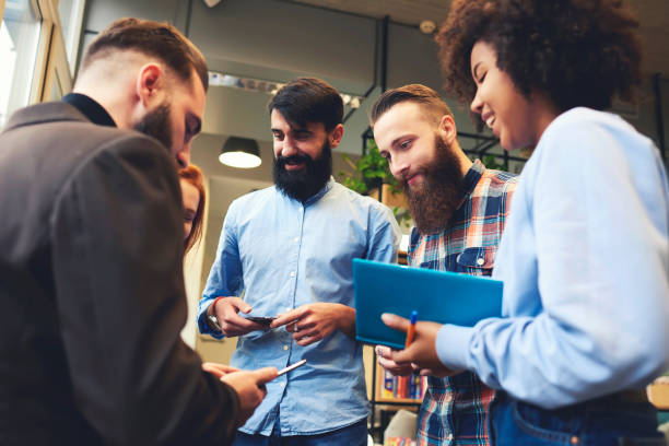 istock Team of skilled copywriters discussing successful strategy for advertising content having fun during blogging web site via modern smartphone connected to wireless internet in office wifi zone 908542556