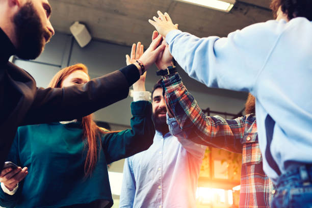 istock Successful team of male and female IT developers celebrating winning award in programming best application for digital devices, giving high-five and  feeling exciting standing in coworking space 908542846