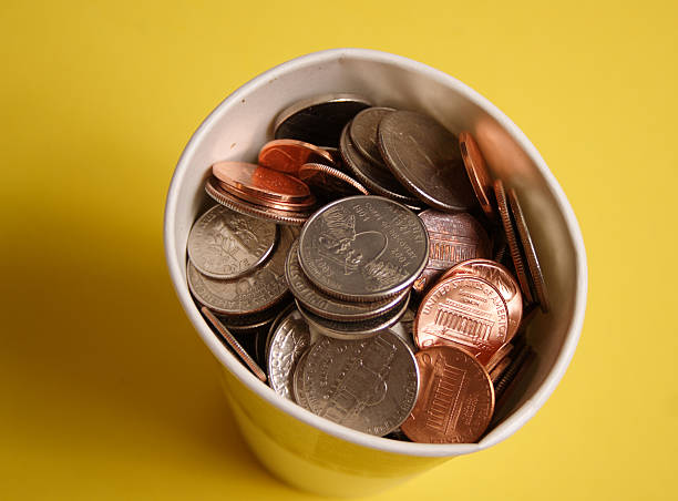 Coins in cup  a penny saved stock pictures, royalty-free photos & images