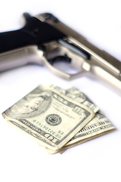 Handgun and money with shallow depth of field.
