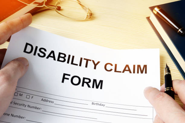 istock Man holding disability claim form for insurance. 908546680